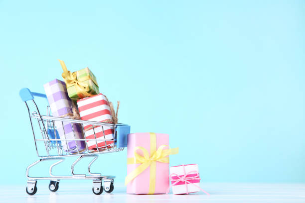 istock Small shopping cart with gift boxes on blue background 1170500705