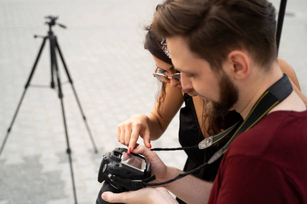 istock Photographer and female model looking through photos 1170501594