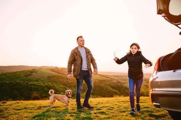 istock Father and daughter with dog camping on hill 1170503662