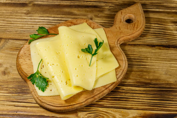 istock Slices of cheese on cutting board on wooden table 1170503721