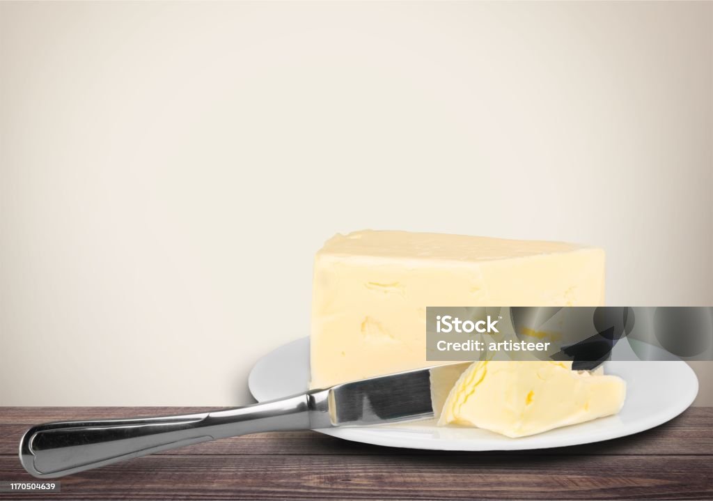 Butter. Pat of fresh farm butter on a butter dish with a knife on backgrouund Butter Stock Photo