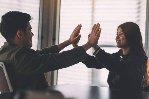 istock Two businesspeople putting their hands to make high five 1170505767