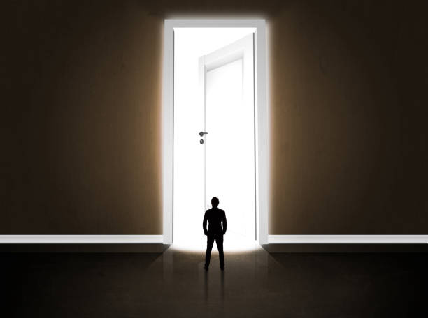 istock Business man looking at big bright opened door 1170510193