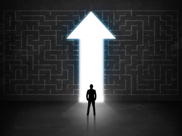 istock Business person looking at maze with solution arrow on the wall 1170510416