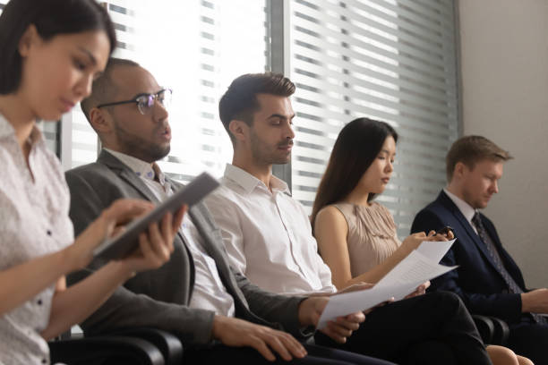 istock Diverse people sit in row waiting for job interview 1170512632