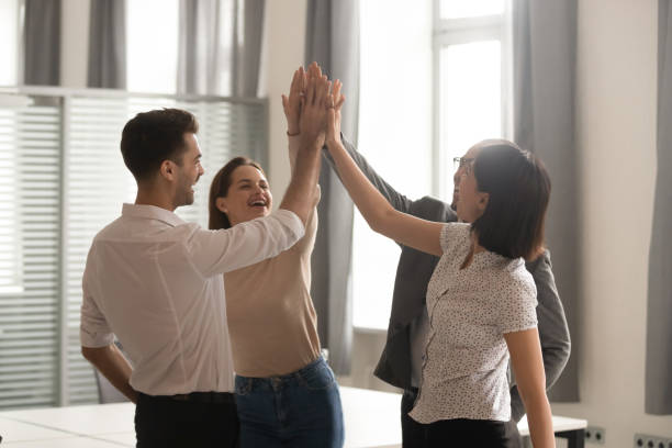 istock Motivated coworkers give high five engaged in teambuilding activity 1170512660