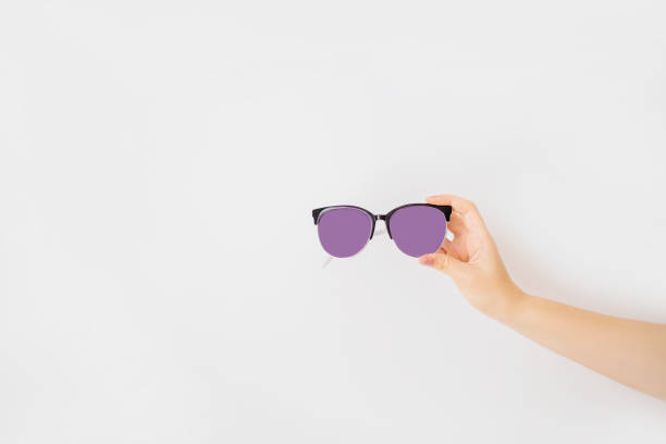istock Female hand holding sunglasses isolated on white background. 1170512804