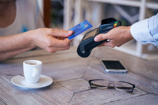 istock Contactless payment with NFC technology at a cafeteria. Attractive active senior woman resting in a cafe while daily running her business - stock photo 1170515906