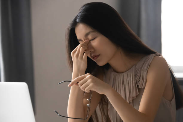 istock Tired Asian employee suffering from headache at work 1170516605