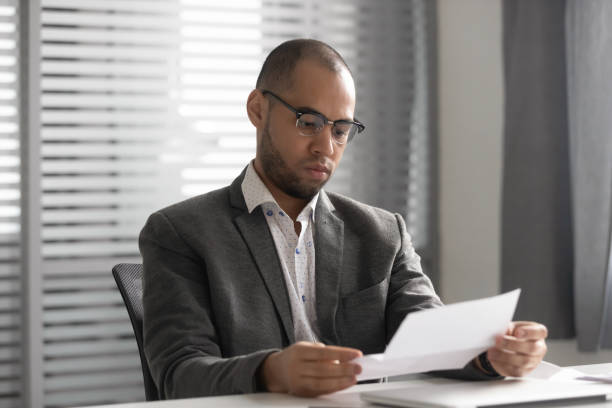 istock Focused male employee reading paper letter at workplace 1170516648