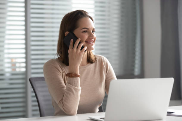 istock Happy female employee talk on cellphone at workplace 1170516656