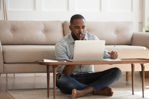 istock Focused african man studying or working on laptop at home 1170519304