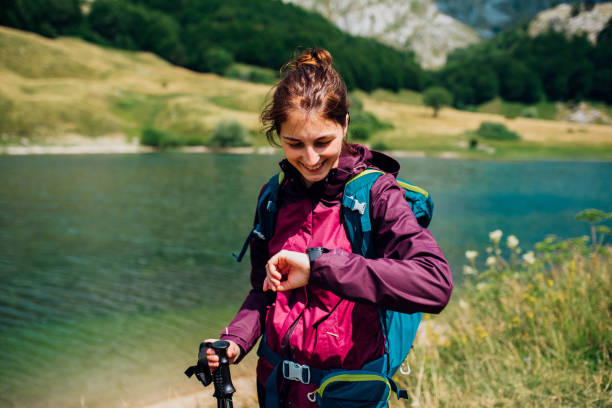 giovane donna che escursionia e controlla la sua pista sul gps - gps watch foto e immagini stock