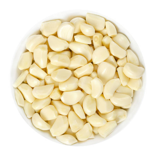 istock Peeled garlic cloves in white bowl over white 1170521719