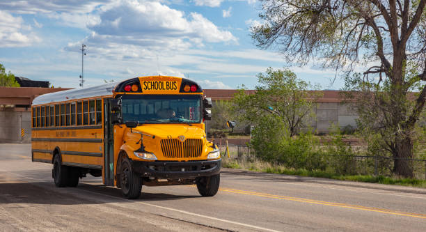 School bus on the road in Chinle, Arizona, USA. Chinle Arizona, USA. May 17, 2019. Classic yellow school bus on the road, sunny spring day chinle arizona stock pictures, royalty-free photos & images