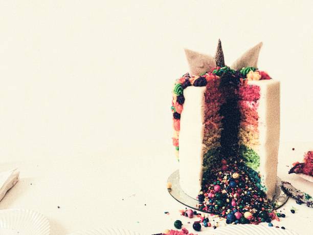 Festive Rainbow Unicorn Cake Background w/Copy Space Festive rainbow unicorn cake sliced revealing brightly colored candy and sprinkles. 21st birthday stock pictures, royalty-free photos & images