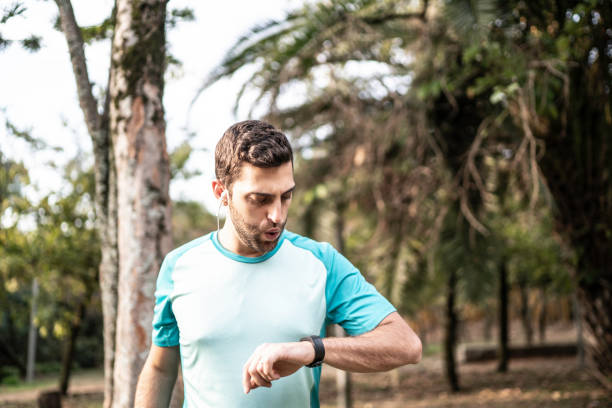 istock Man checking his smartwatch after running in a park 1170527319