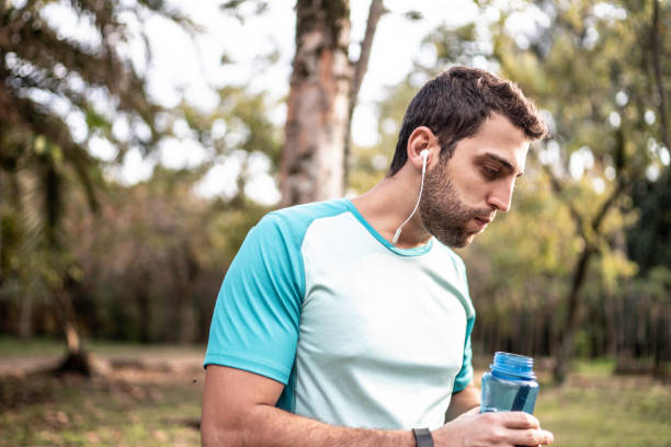 istock Athlete drinking water after running in a park 1170528517