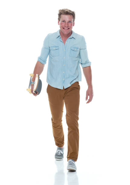 istock Casual well dressed man walking with a skateboard 1170532107