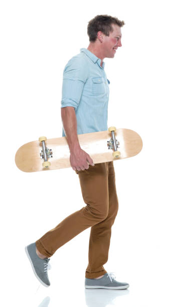 istock Casual well dressed man walking with a skateboard 1170532575