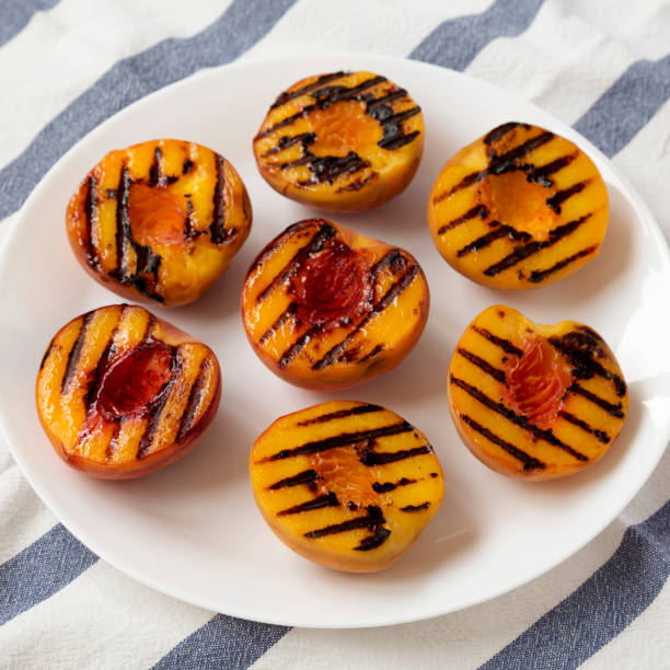 istock Homemade grilled peaches on a white plate, low angle view. Close-up. 1170536026