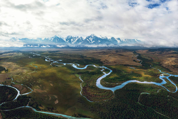 Kurai steppe and Chuya river Kurai steppe and Chuya river on North-Chui ridge background. Altai mountains, Russia. Aerial drone panoramic picture. altai nature reserve photos stock pictures, royalty-free photos & images