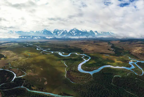 Kurai steppe and Chuya river on North-Chui ridge background. Altai mountains, Russia. Aerial drone panoramic picture.