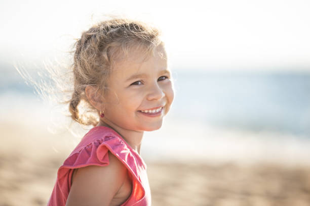 istock Smiling cute little girl in sunny day on beach 1170536708