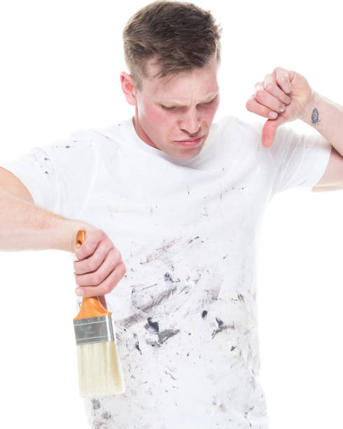 istock Handsome young male painter wearing staned clothes  on white background - thumbs down 1170536892
