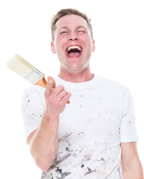 istock Handsome young male painter wearing staned clothes  on white background - finger gun 1170537024