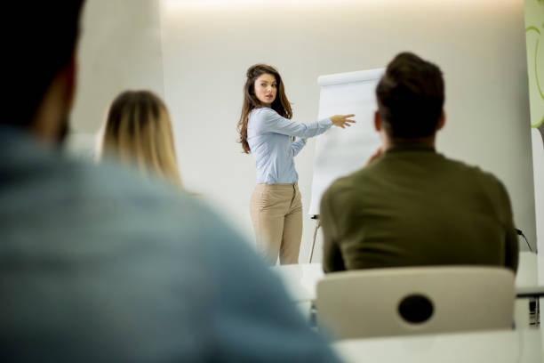 istock Creative positive female leader talking about business plan with students during workshop 1170540567