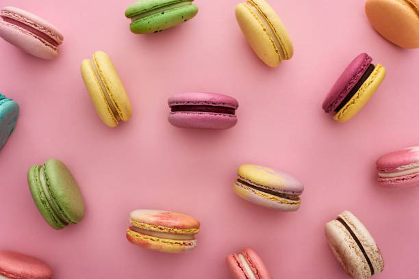 istock pattern of multicolored fresh French macaroons scattered on pink background 1170541804