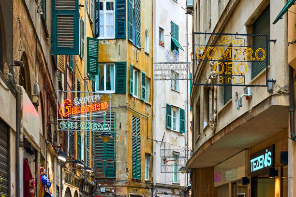 Genoa, Italy - July 06, 2019: Old street with signboards of shops and cafes in Genoa