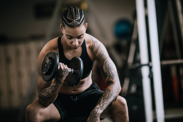 mujer fuerte y en forma haciendo ejercicio en el gimnasio - human muscle women bicep girl power fotografías e imágenes de stock