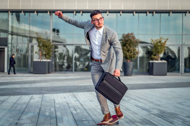 istock Stylish manager riding a skateboard in city 1170545220