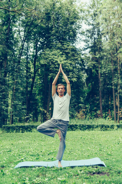 istock Young sporty guy makes breathing exercise 1170549172