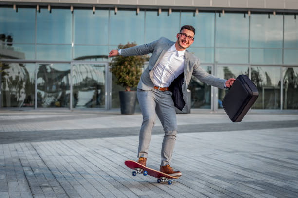 istock Stylish manager riding a skateboard in city 1170552759