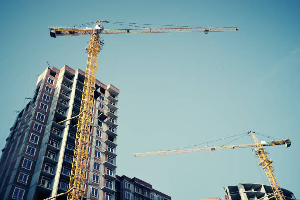 Construction site, building a new houses, crane, blue sky. No recognizable people