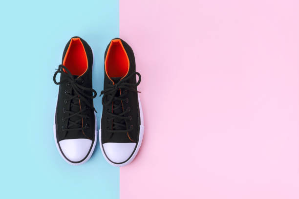 istock New black sneakers on pink and blue background with copy space. 1170557955