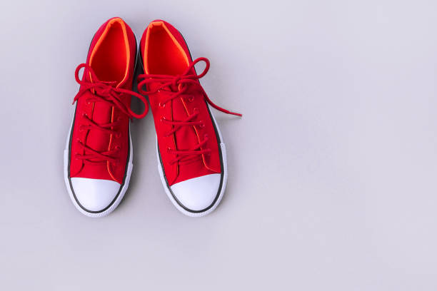 istock New red sneakers on grey background with copy space. 1170558123