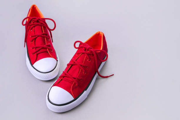 istock New red sneakers on grey background with copy space. 1170558124