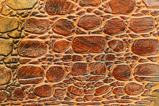 Brown scales macro exotic background, embossed under the skin of a reptile, crocodile. Texture genuine leather close-up, golden brown tones, fashion trend