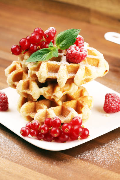 istock Traditional belgian waffles with fresh mint, sugar and raspberries on table 1170561699