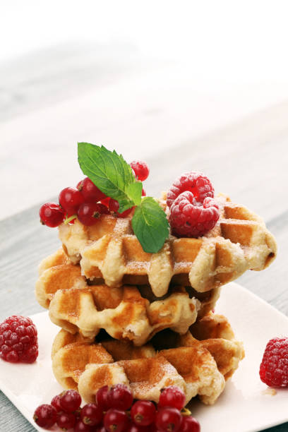 istock Traditional belgian waffles with fresh mint, sugar and raspberries on table 1170561945