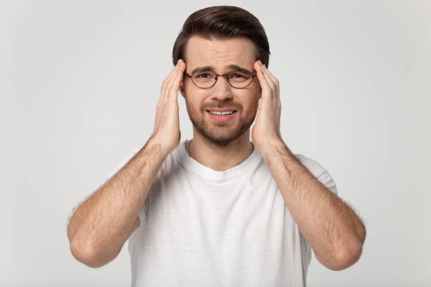 istock Stressed man touching temples suffering from headache studio shot 1170564013