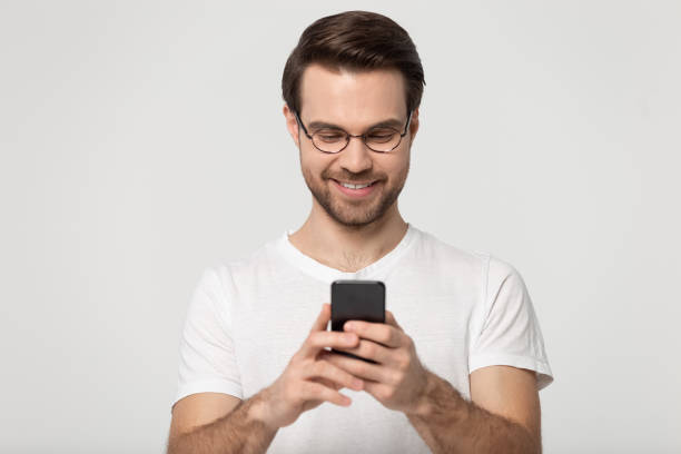 istock Man holding smartphone chatting with friends online studio shot 1170564034