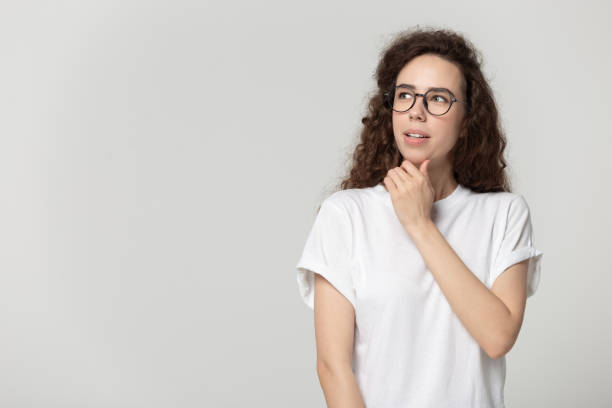 istock Attractive woman in glasses thinking posing isolated on grey background 1170566390