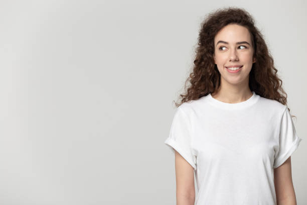 istock Attractive young woman standing aside looking at copyspace grey background 1170566405