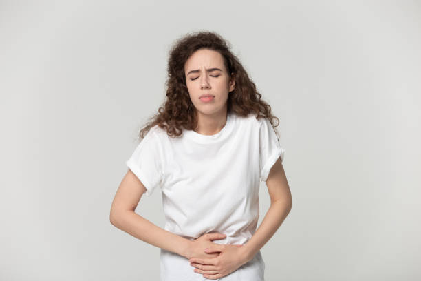 istock Girl touching stomach suffering from severe ache isolated on grey 1170566507