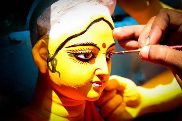 Kolkata; India - Asia; An artist gives final touches to idol of hindu Goddess Durga in workshop made of Plaster of Paris Clay at Kumortuli for upcomming Durgapuja festival